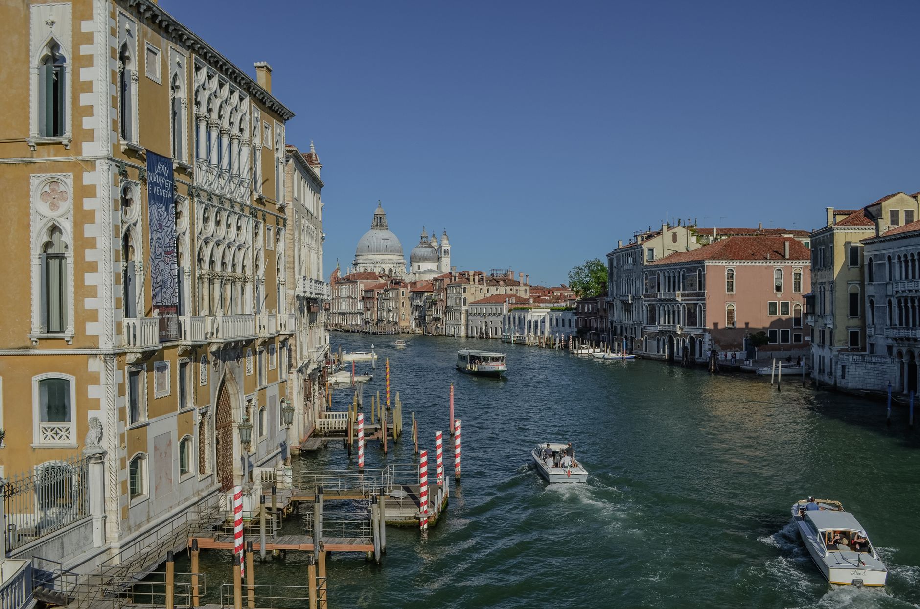 Venice's Grand Canal with boats and historic buildings under a clear sky