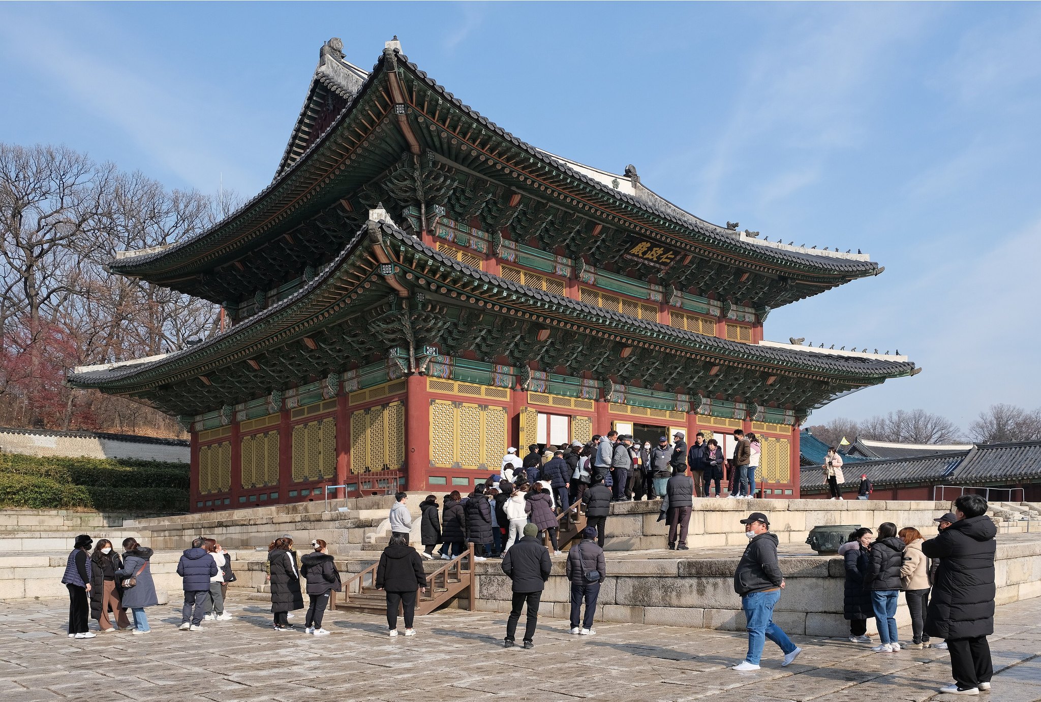 Visitors gathered on the stone terrace in front of Injeongjeon