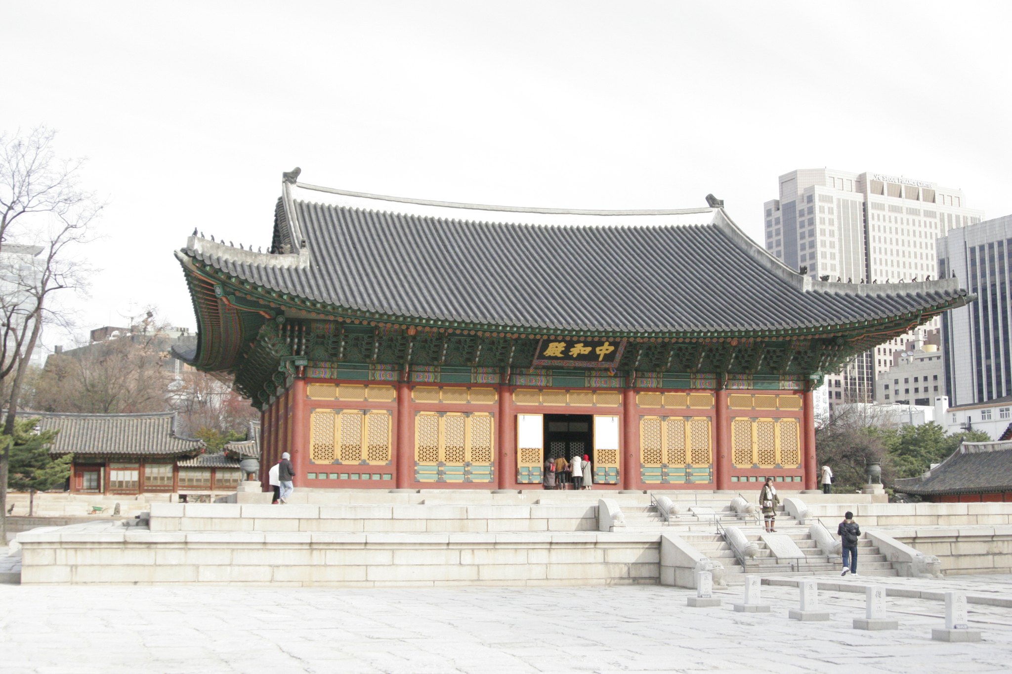 Deoksugung's throne hall low against the glass office towers of central Seoul
