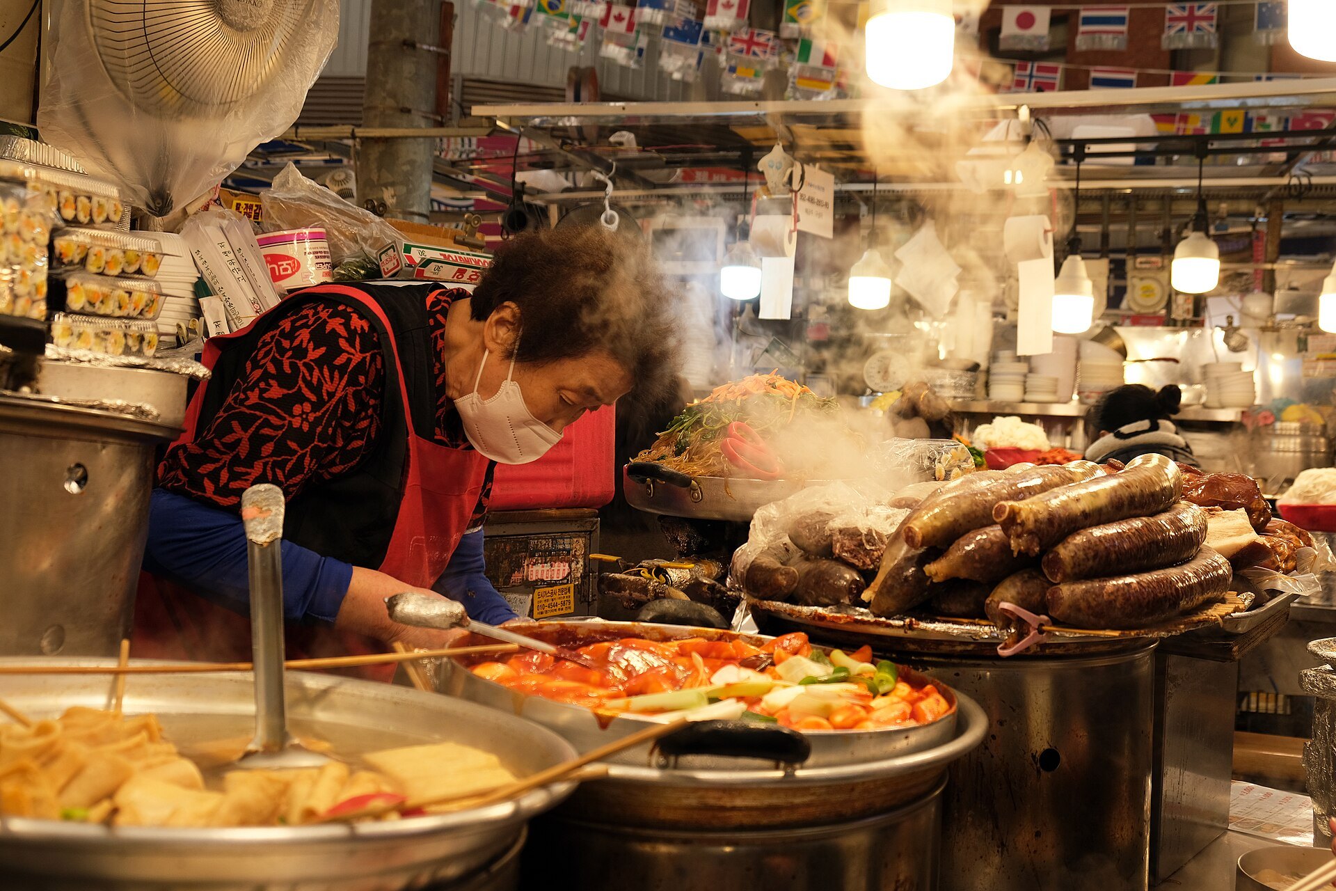 Steam rising from a vendor's pans of fried food at Gwangjang Market