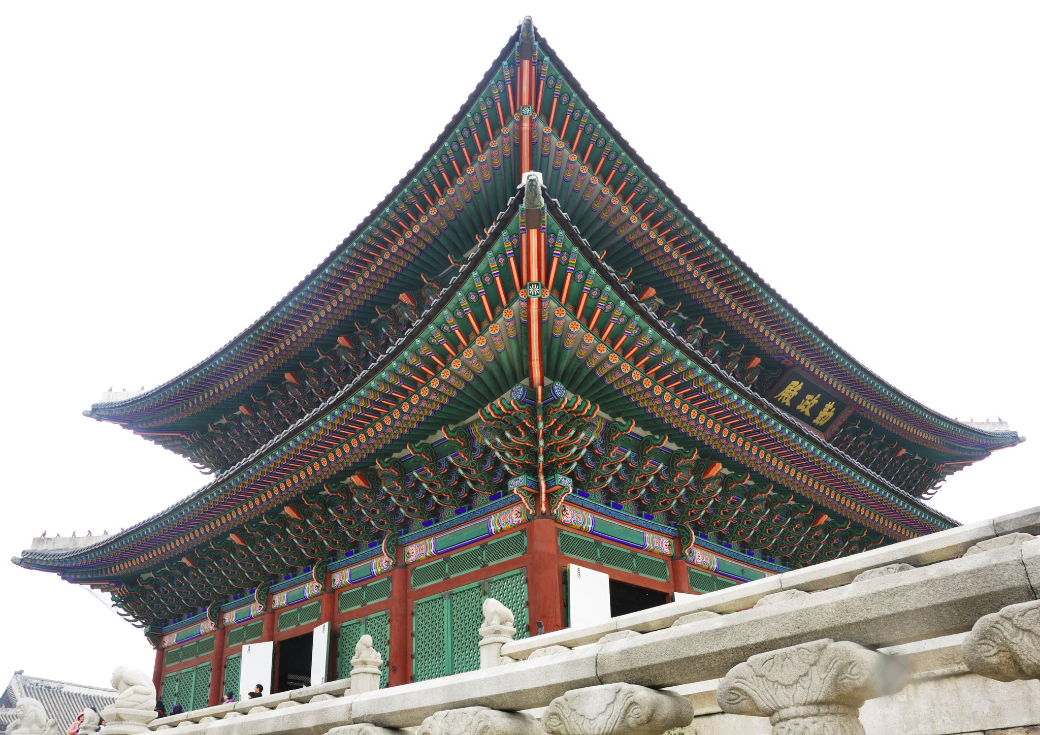 The bracketed and painted eaves of Geunjeongjeon seen from below against a clear sky