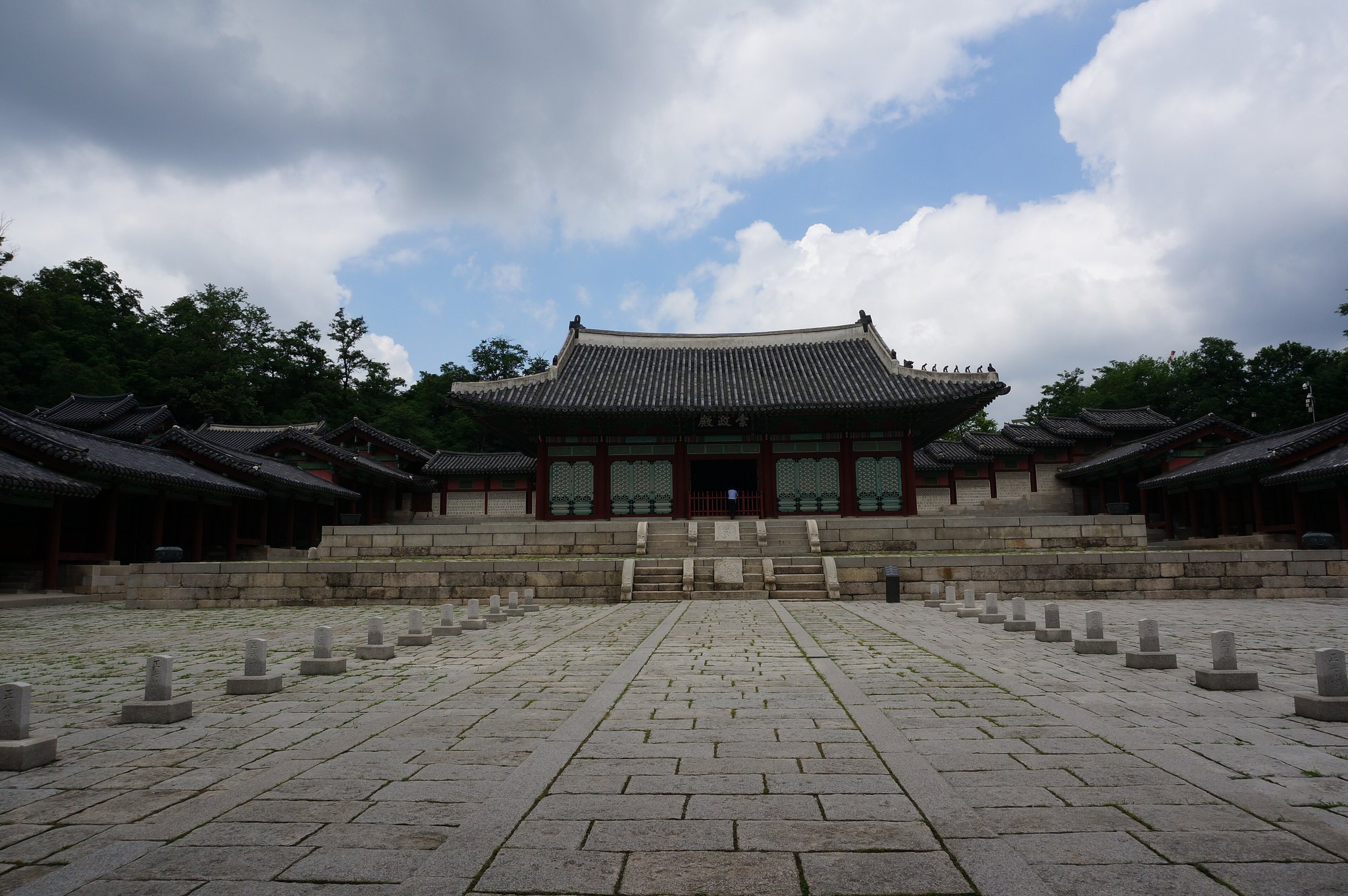 The wide stone forecourt of Gyeonghuigung beneath heavy cloud