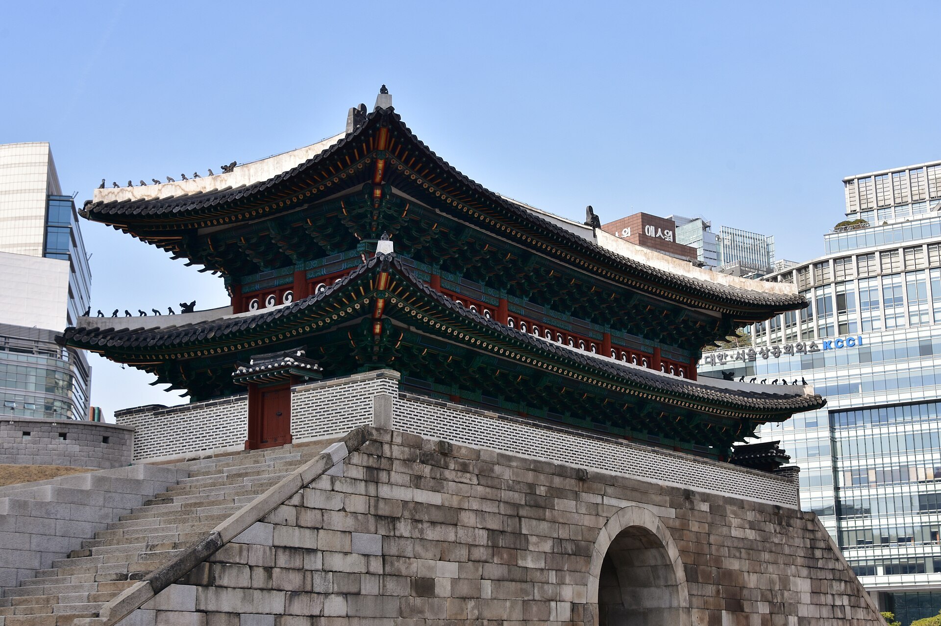 The rebuilt Sungnyemun gate standing against the glass office towers behind it
