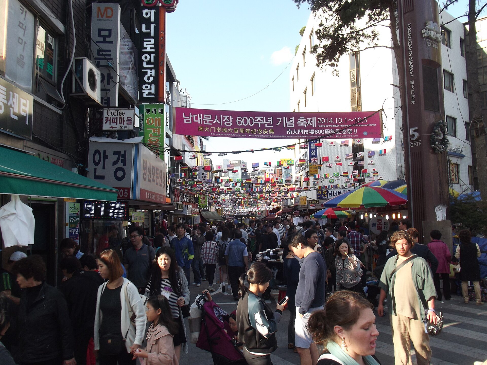 A busy Namdaemun Market street seen along the length of the stalls