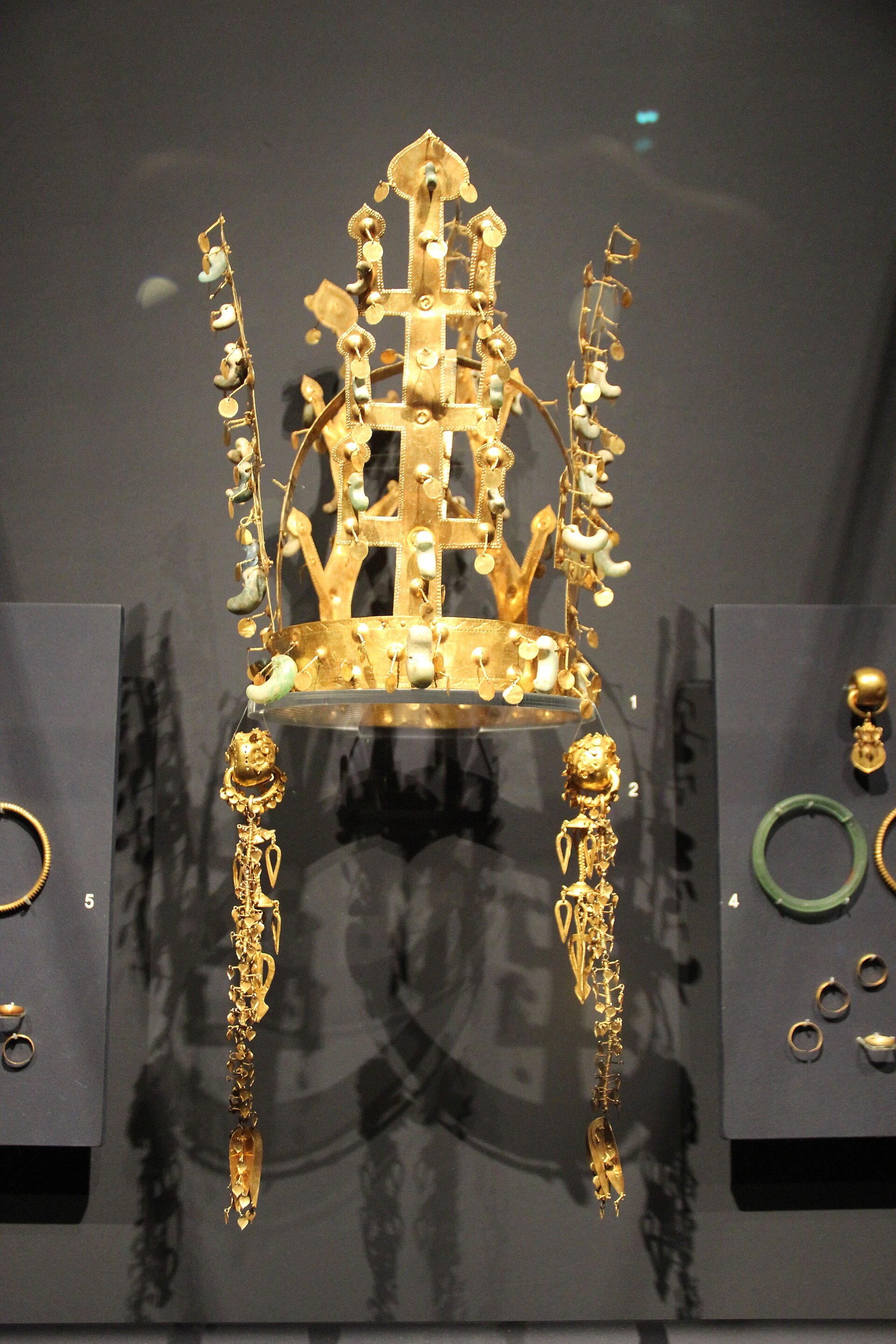 A gold crown of the Silla kingdom lit in a dark museum case