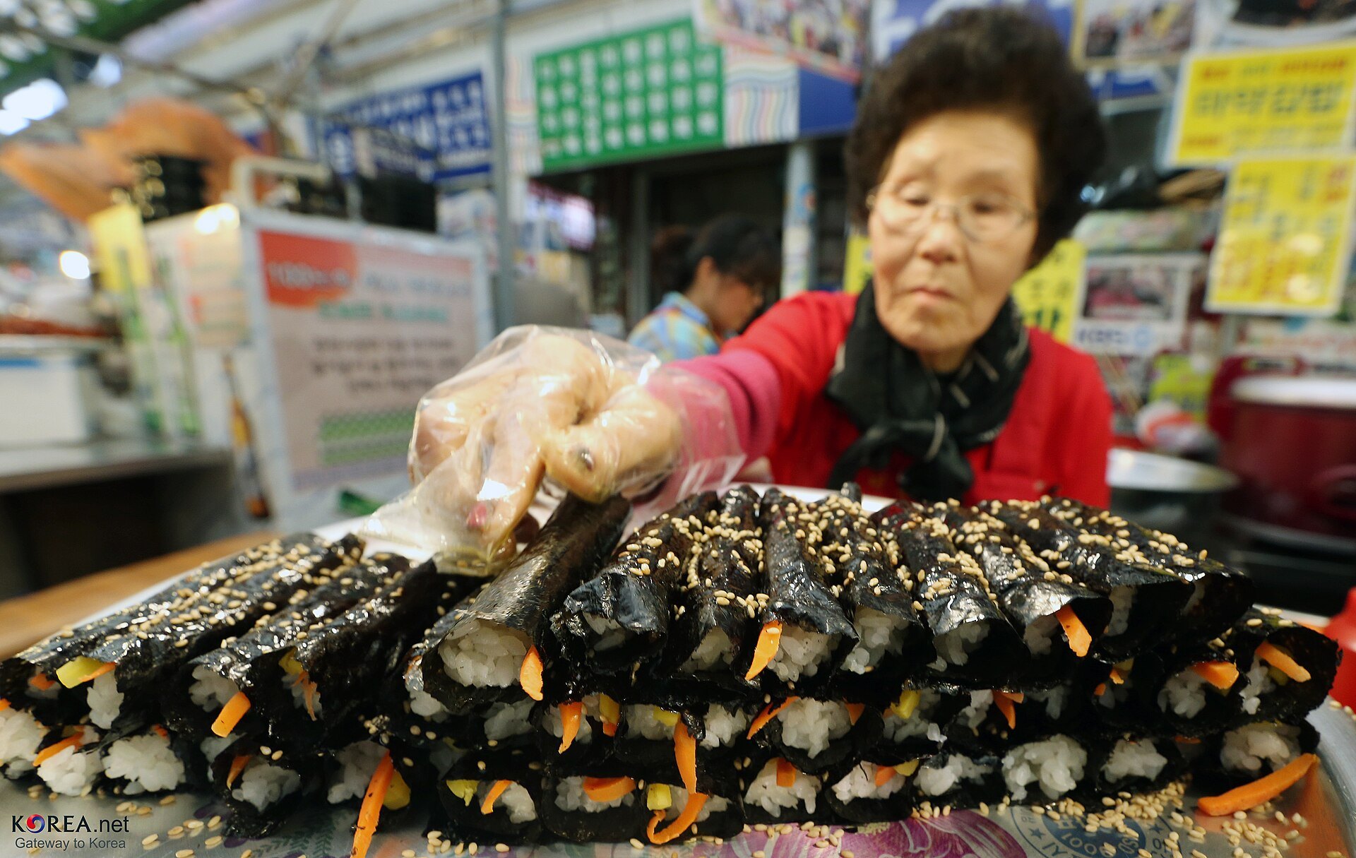 A vendor rolling gimbap at a market stall in Seoul