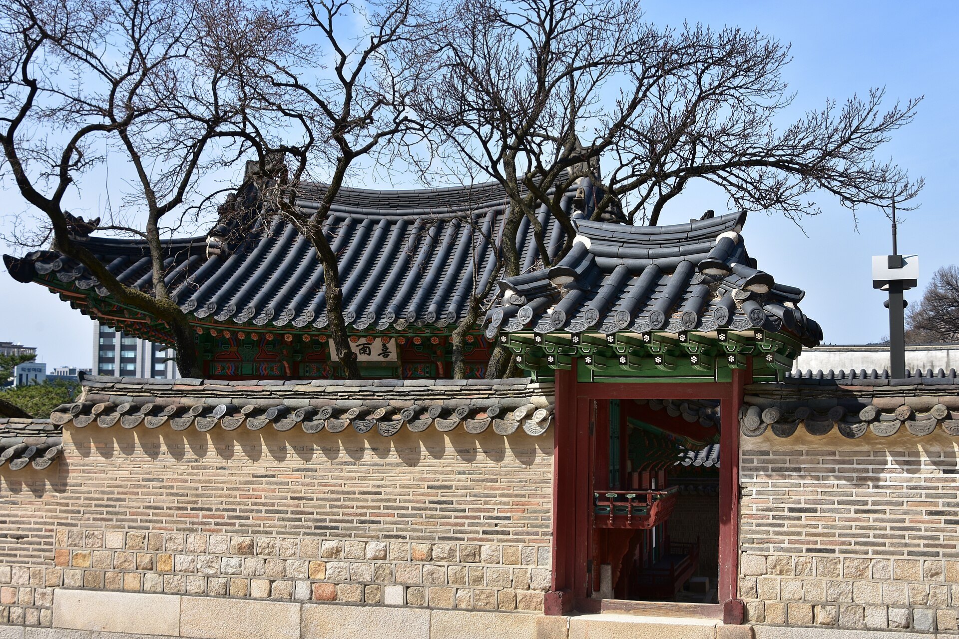 Tiled palace roofs and a red-pillared gate at Changdeokgung